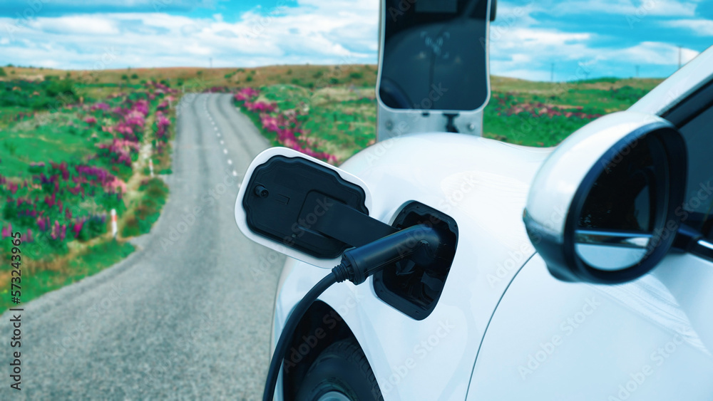 Progressive concept for environmental awareness by electric car at the charging station on the hill 