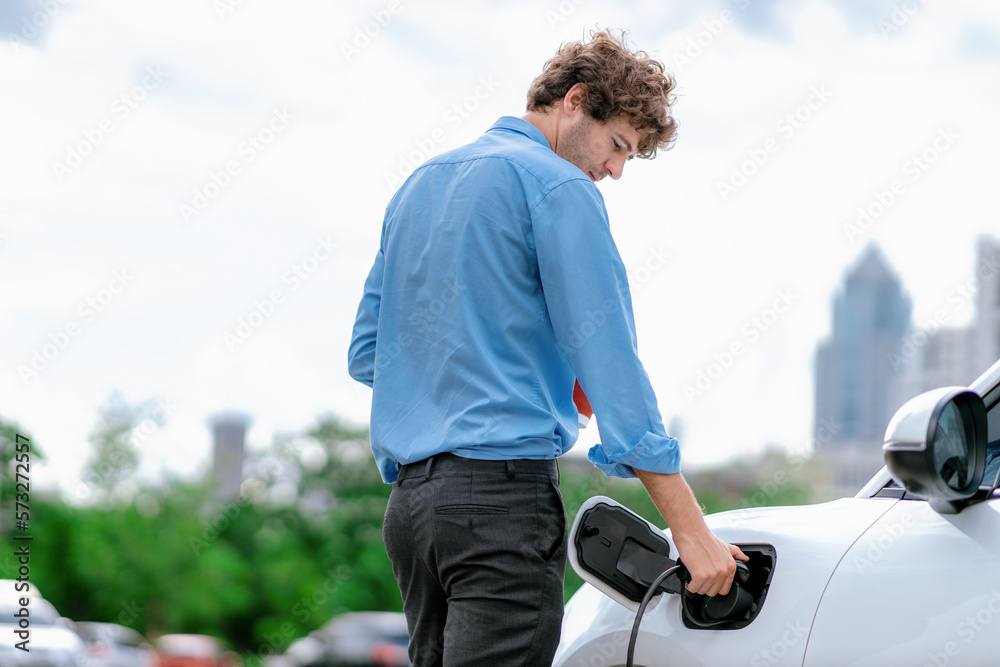 Progressive eco-friendly concept of parking EV car at public electric-powered charging station in ci