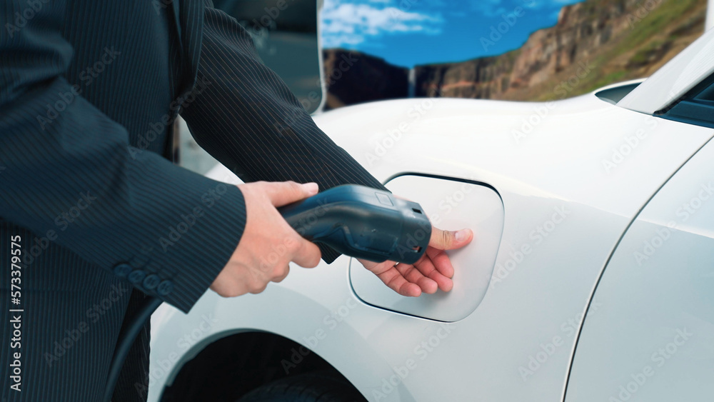 Progressive man recharge electric vehicle installing power cable plug from charging station with rur