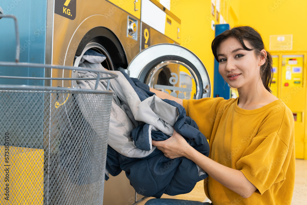 Asian people using qualified coin operated laundry machine in the public room to wash their cloths. 