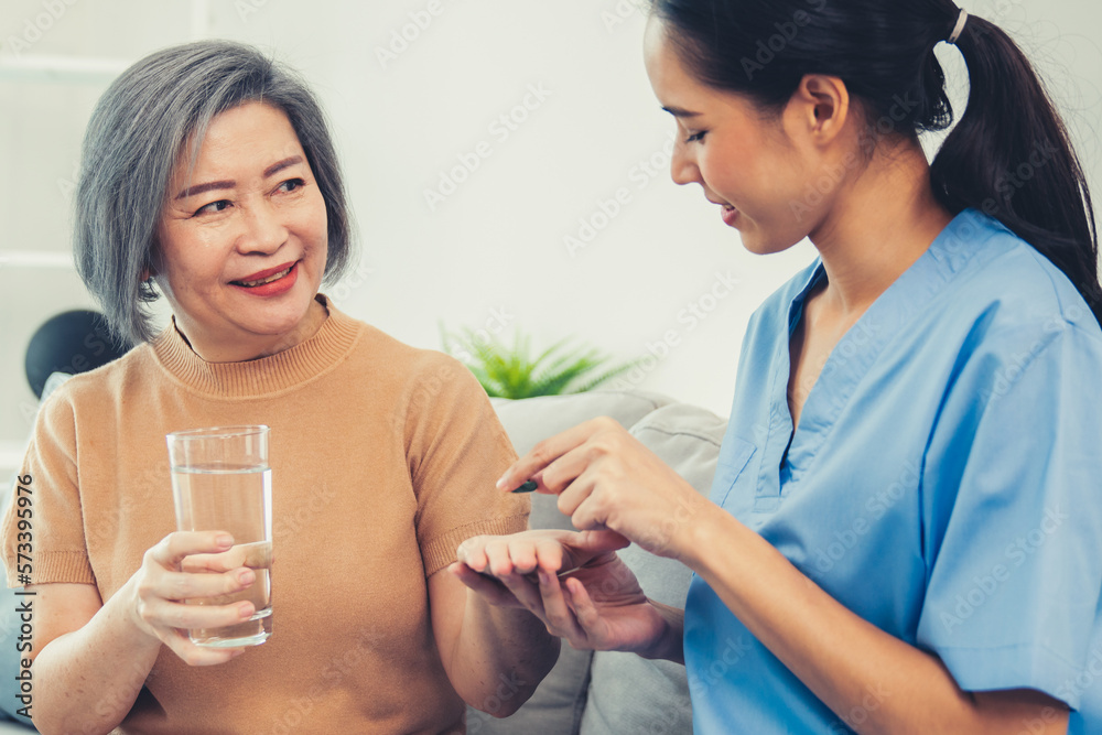 Contented senior woman taking medicines while her caregiver advising her medication. Medication for 