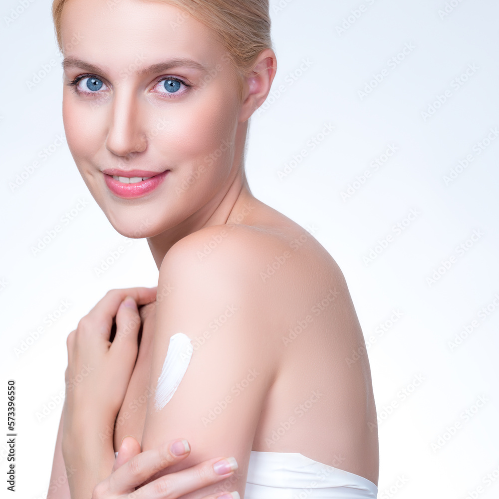 Closeup personable beautiful woman putting skincare moisturizer cream on her arm looking in camera i