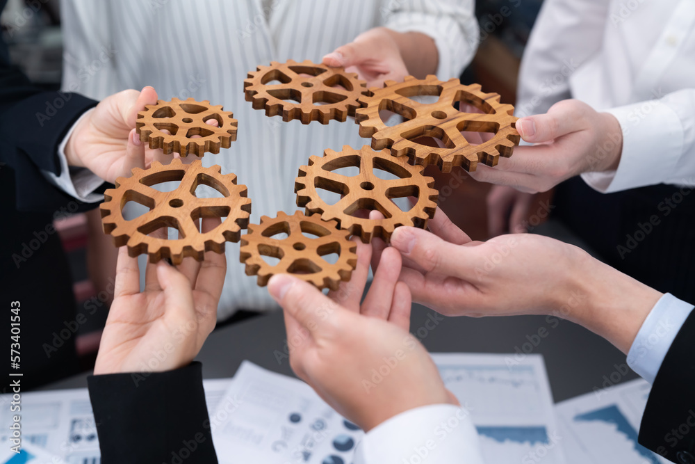 Closeup top view businesspeople hand holding gear and join together over meeting table with financia