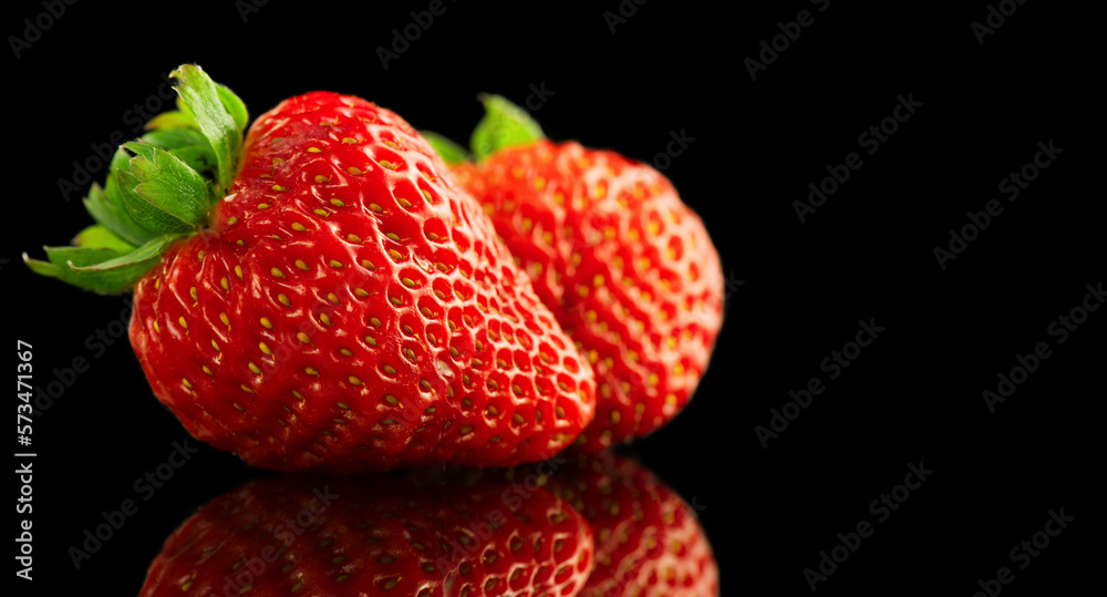 Strawberries isolated on a black background. Two Fresh ripe strawberries on black. Macro shot