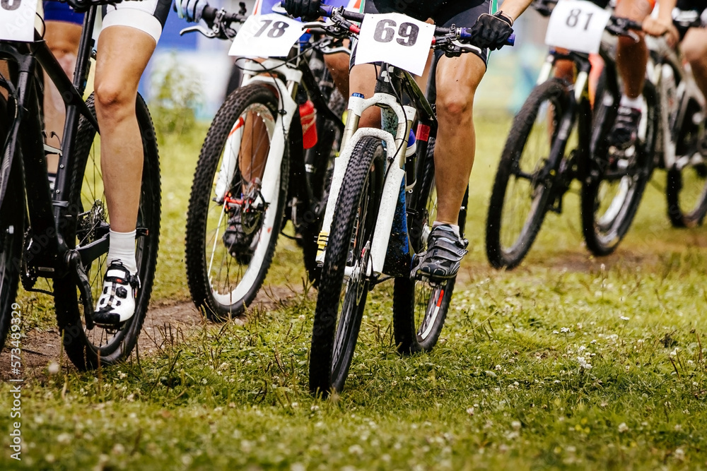 legs and wheels of bicycle riders cyclists. mountain bike race