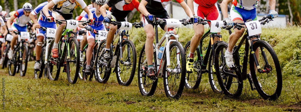 peloton riders cyclists riding on trail. mountain bike competition