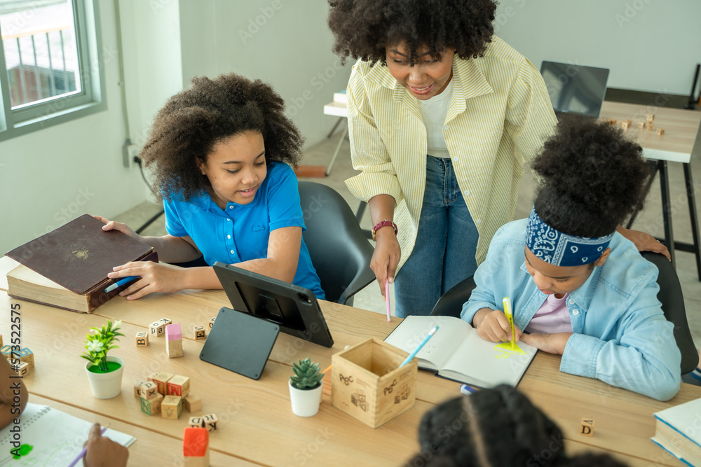 Black girl in classroom with diverse group of children learning new stuff,In elementary school class