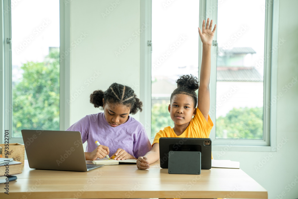 Young African American children sitting at school desk attentively listening to his teacher,Student 