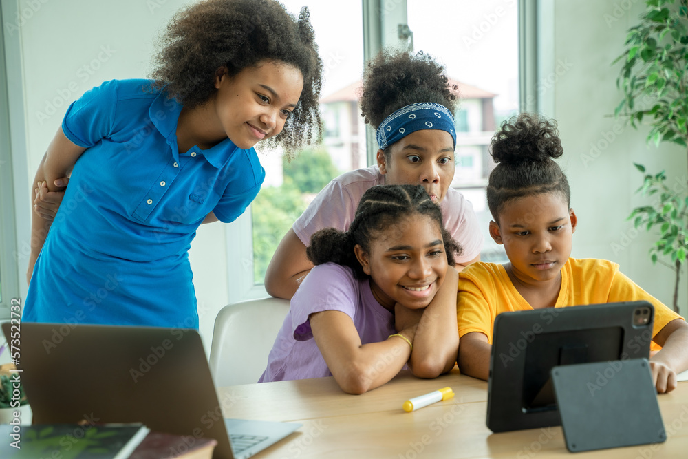 Young African American children sitting at school desk attentively listening to his teacher,Student 