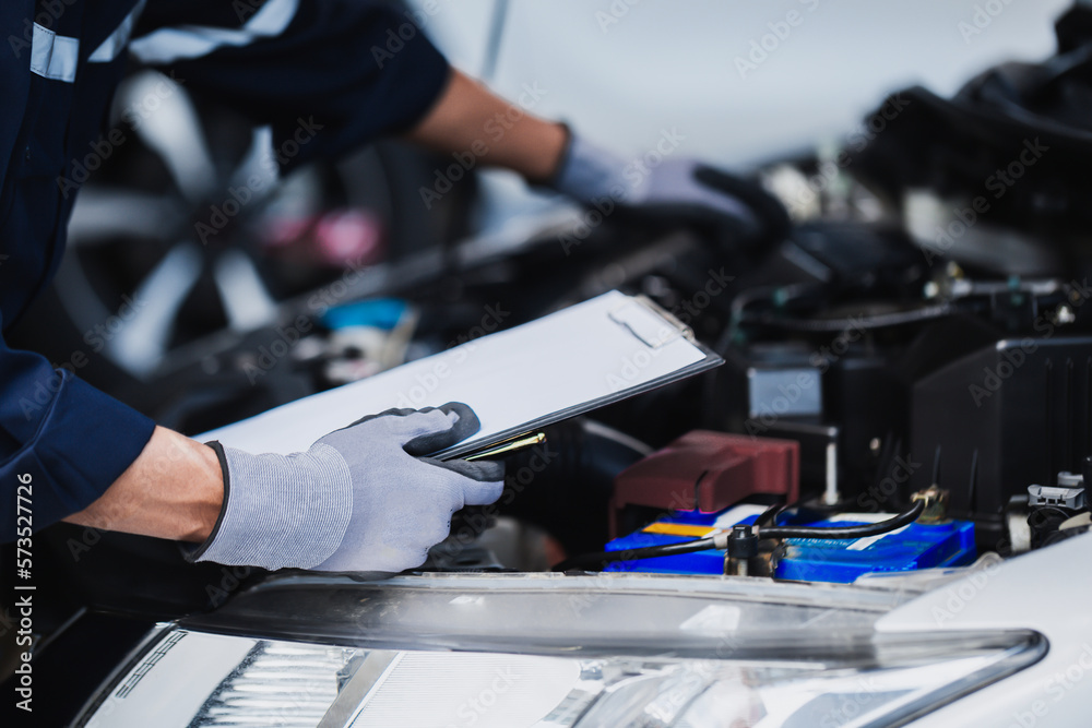 Professional mechanic working on the engine of the car in the garage. Car repair service.