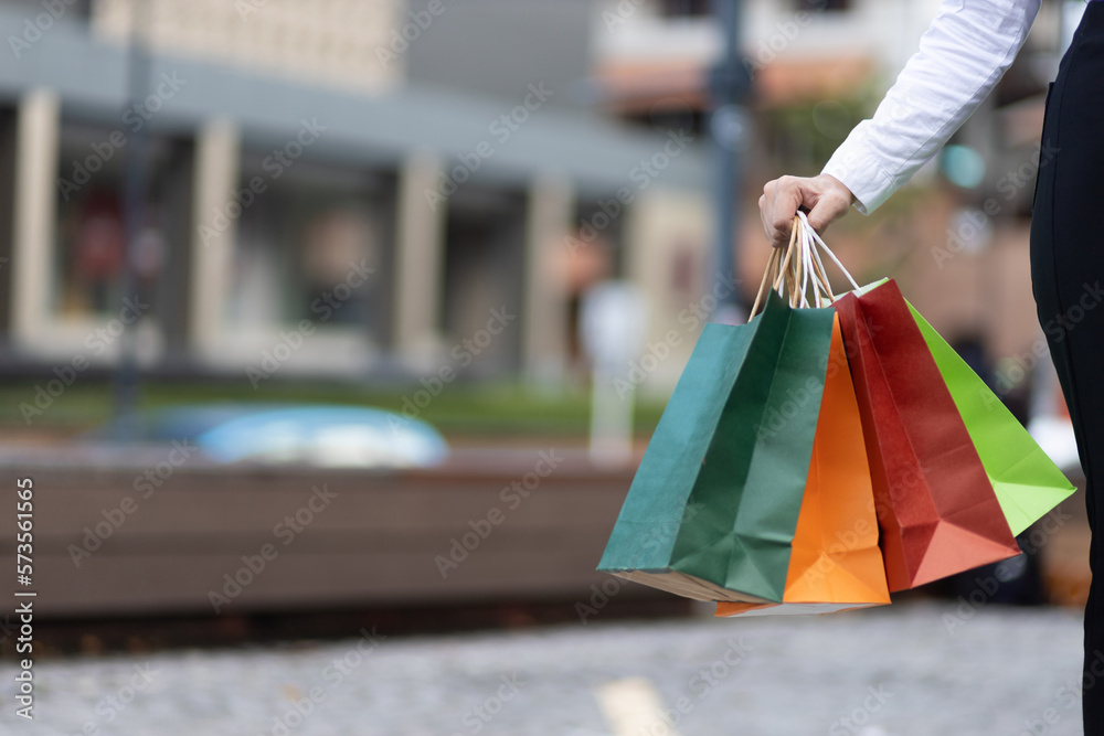 Cheerful and attractive young Asian woman carrying shopping bags. Female tourist carrying shopping b