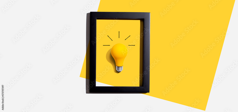 Yellow light bulb inside a frame - inspiration, creativity, energy, electricity themes