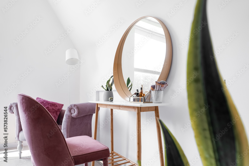 Interior of light makeup room with table, mirror and chairs