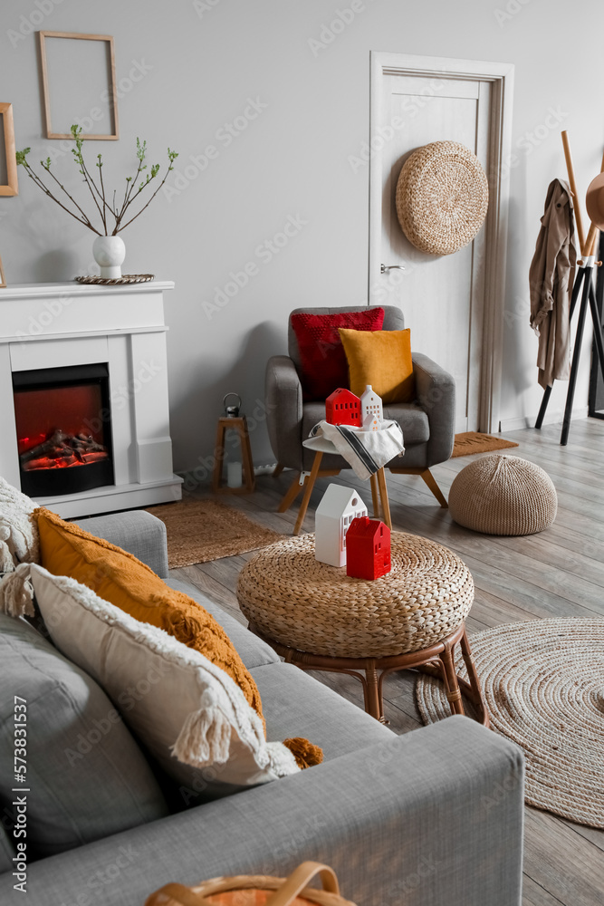 Interior of living room with fireplace, armchair and house candle holders