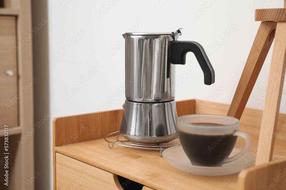 Geyser coffee maker and cup of espresso on nightstand table