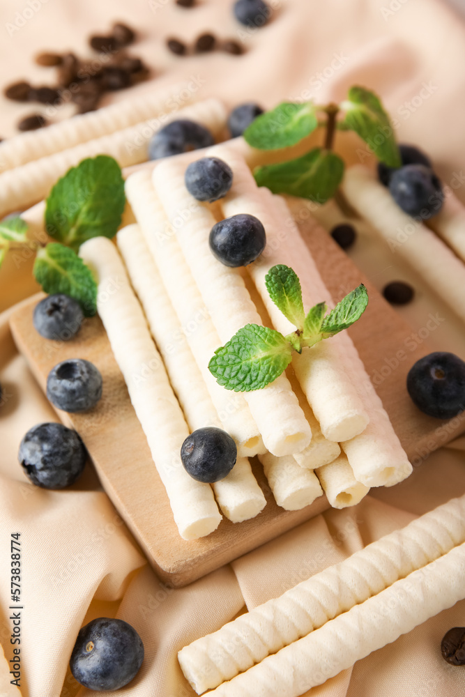 Napkin with delicious wafer rolls, blueberries, coffee beans and mint, closeup