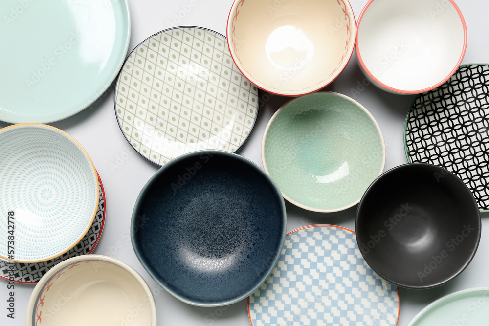 Composition with clean ceramic plates and bowls on white background