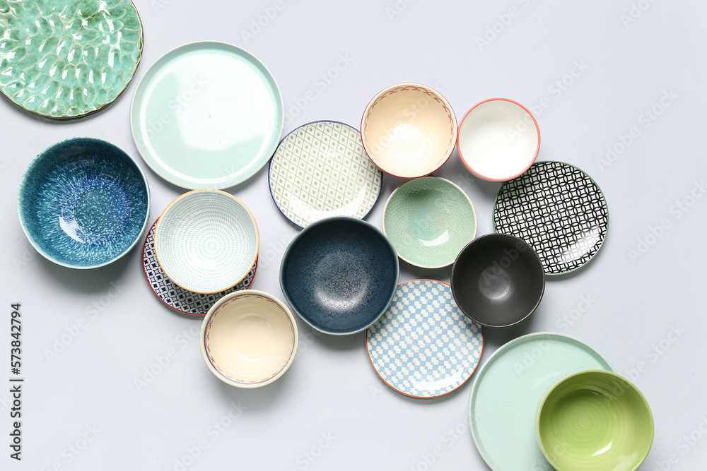 Composition with clean ceramic plates and bowls on white background