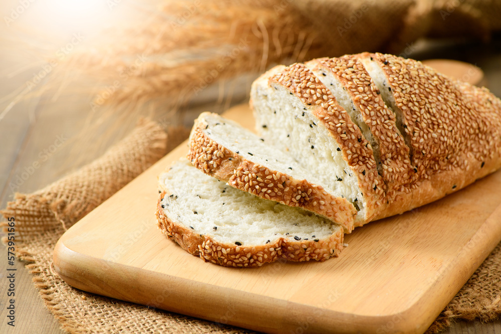 sliced french grain breads with white and black sesame on wood background