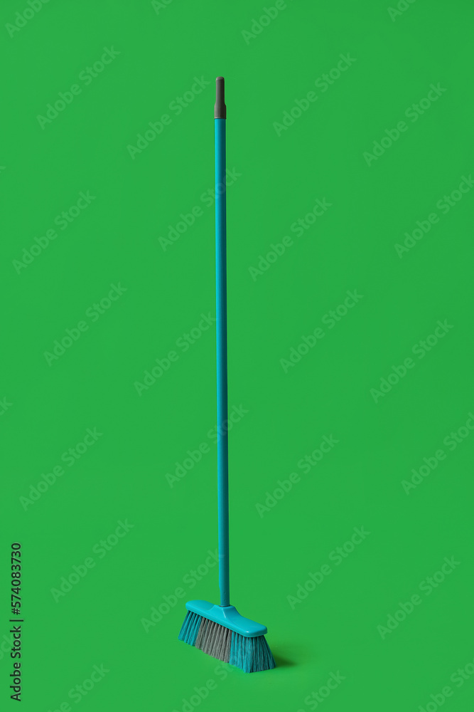 Plastic cleaning broom on green background