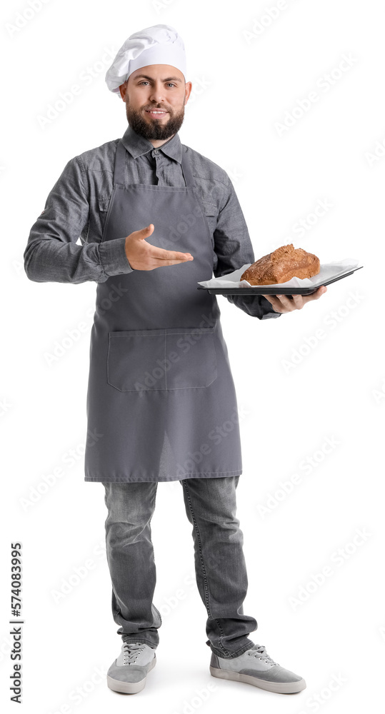 Male baker holding tray with rye bread on white background