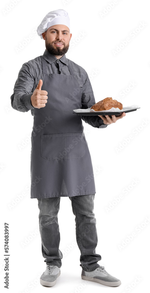 Male baker holding tray with rye bread showing thumb-up on white background