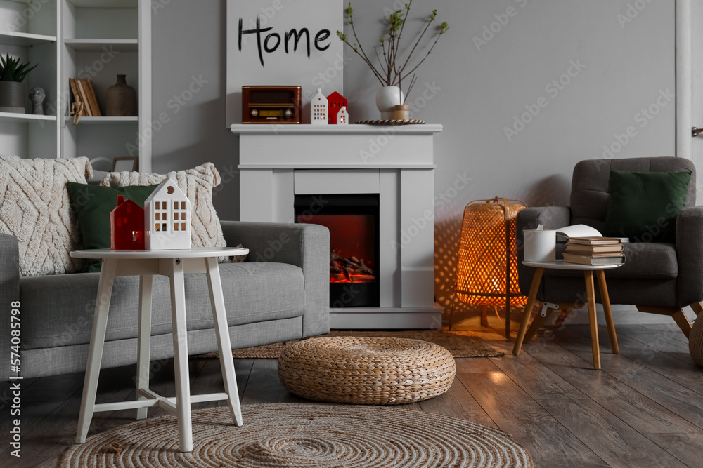 Interior of living room with fireplace, tables and house candle holders