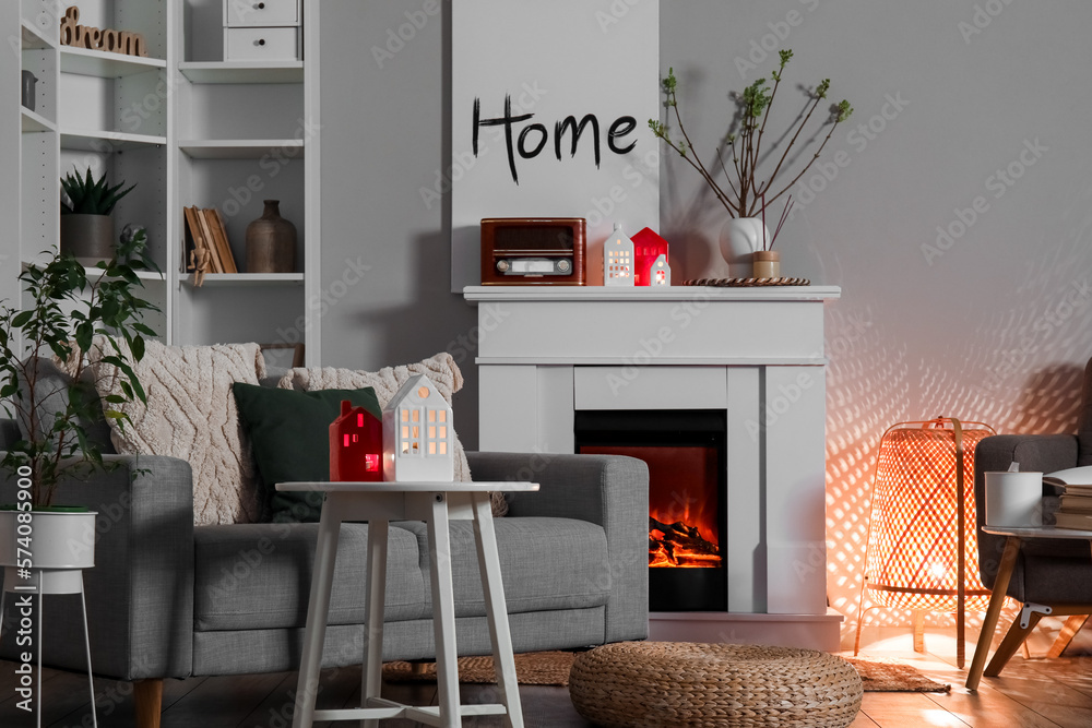 Interior of living room with fireplace, glowing lamp and candle holders