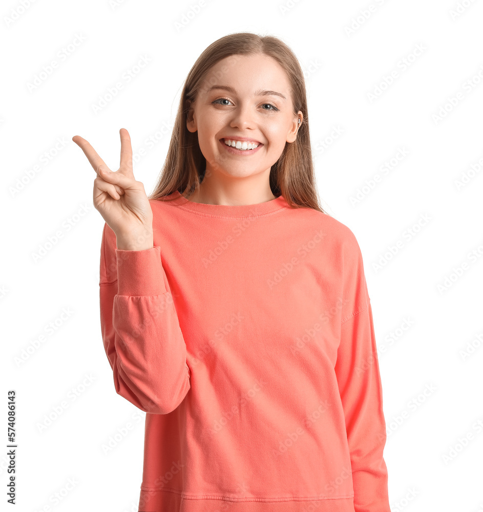 Young woman in red sweatshirt showing victory gesture on white background