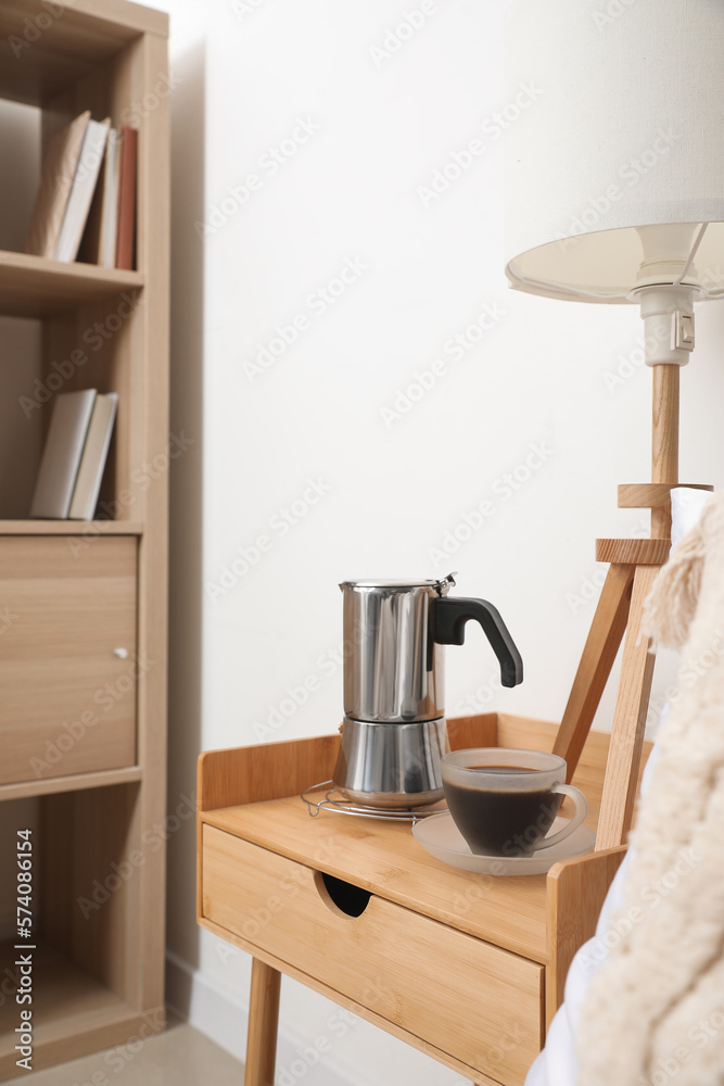 Geyser coffee maker and cup of espresso on nightstand table