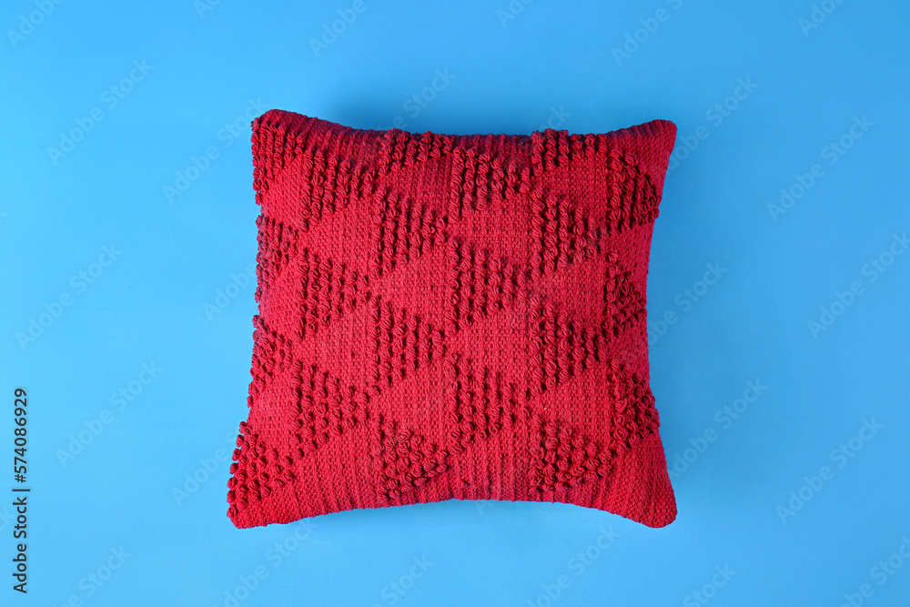 Stylish red pillow on blue background