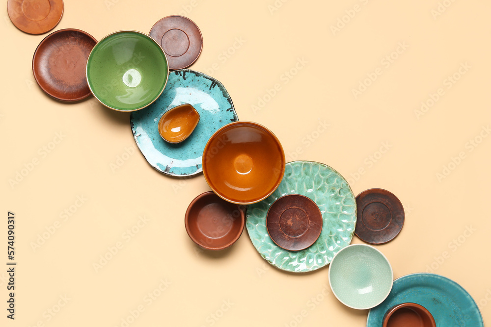 Composition with clean ceramic plates and bowls on beige background