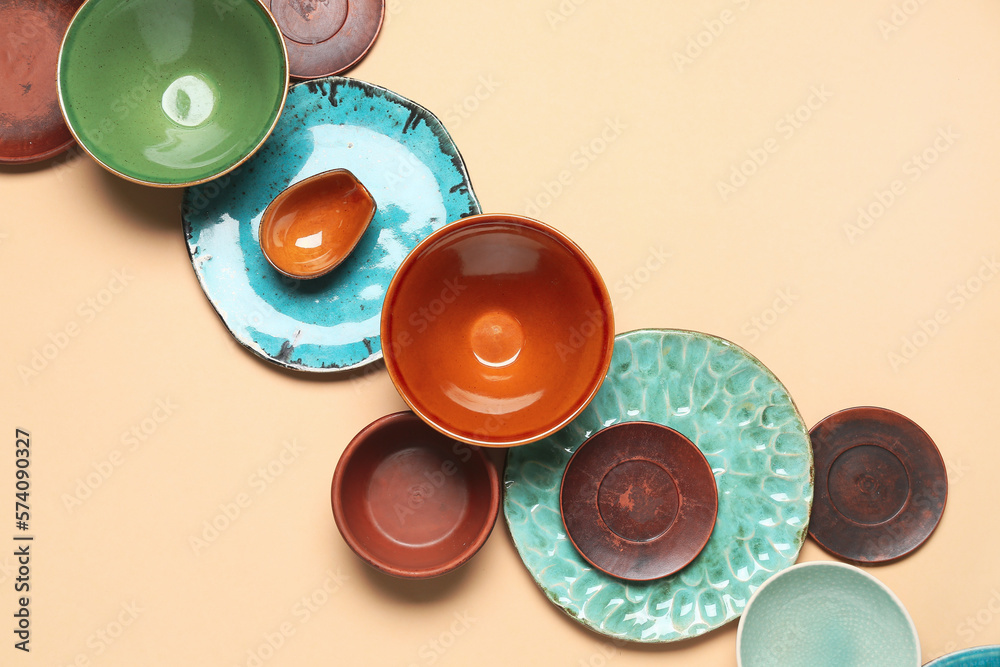 Composition with clean ceramic plates and bowls on beige background