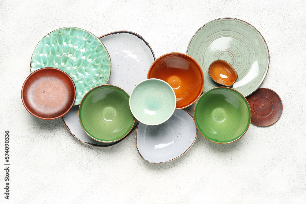 Composition with clean ceramic plates and bowls on white background