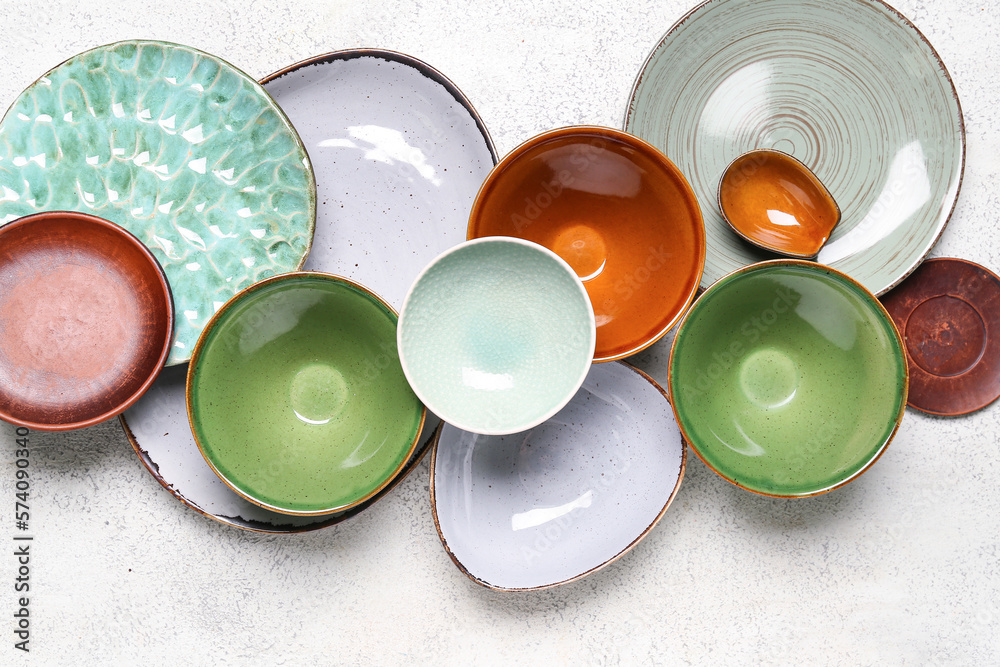 Composition with clean ceramic plates and bowls on white background