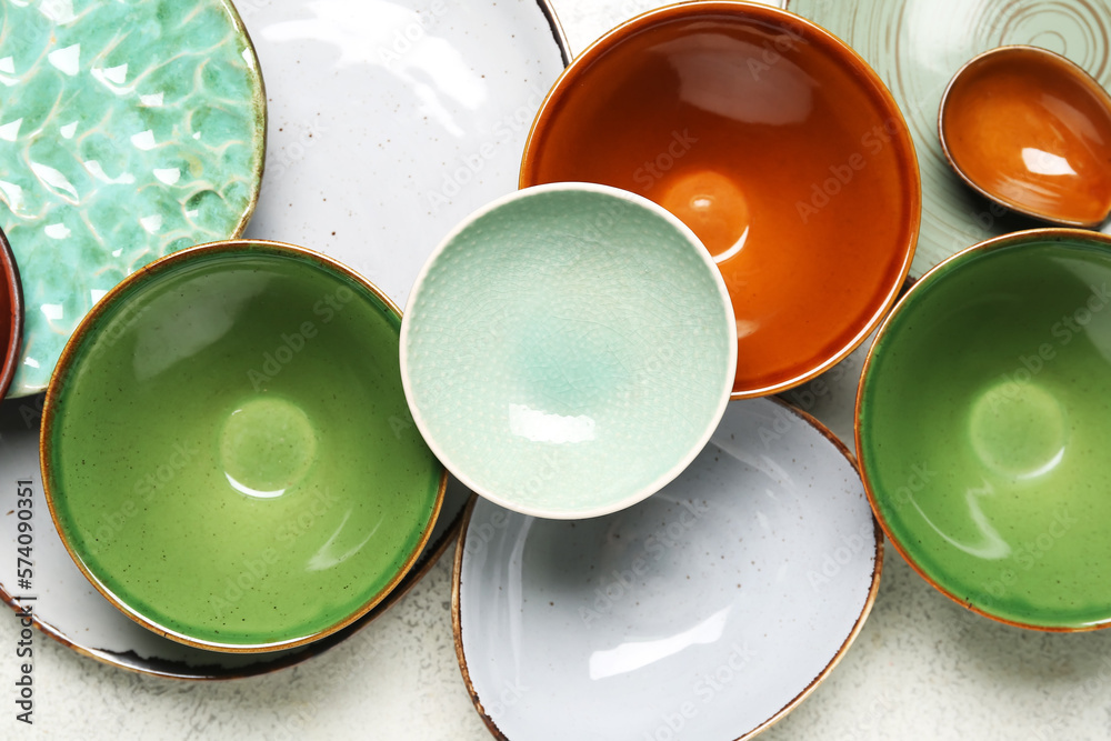 Composition with clean ceramic plates and bowls on white background