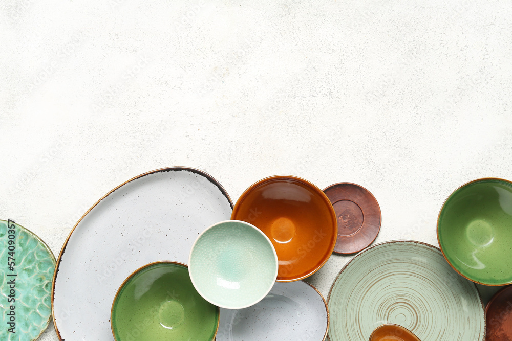 Composition with clean ceramic plates and bowls on white background