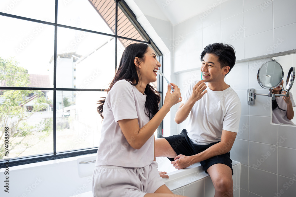 Asian new marriage couple brushing teeth together in bathroom at home. 