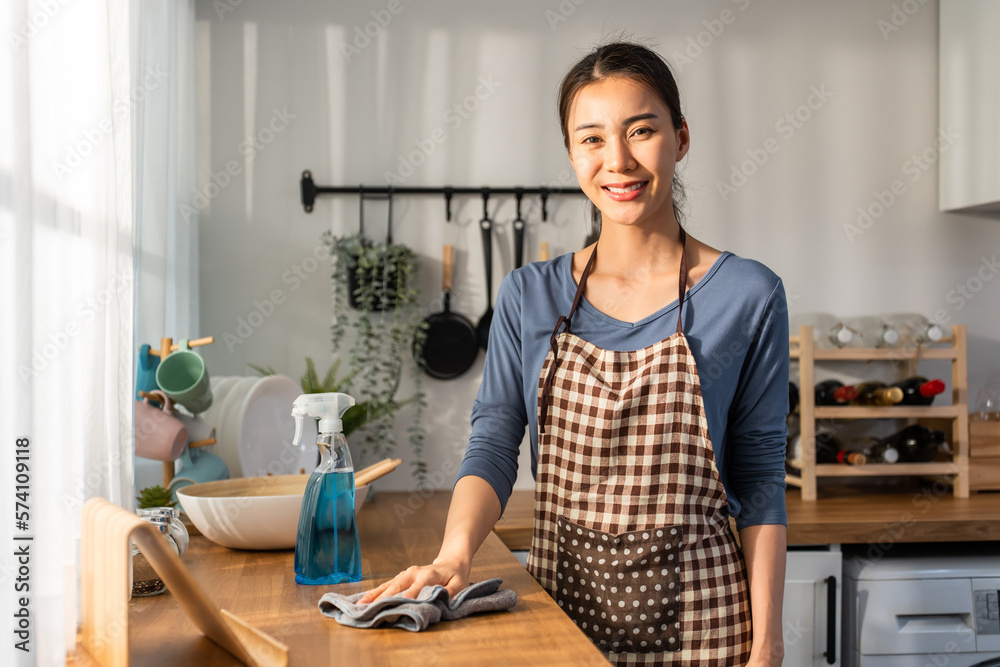 Asian beautiful cleaning service woman worker cleaning kitchen at home.