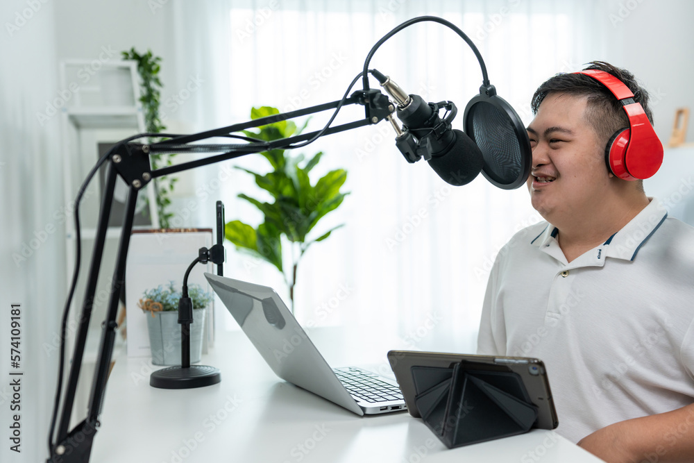 Young trendy DJ man wearing headphone and speak on microphone at studio. 