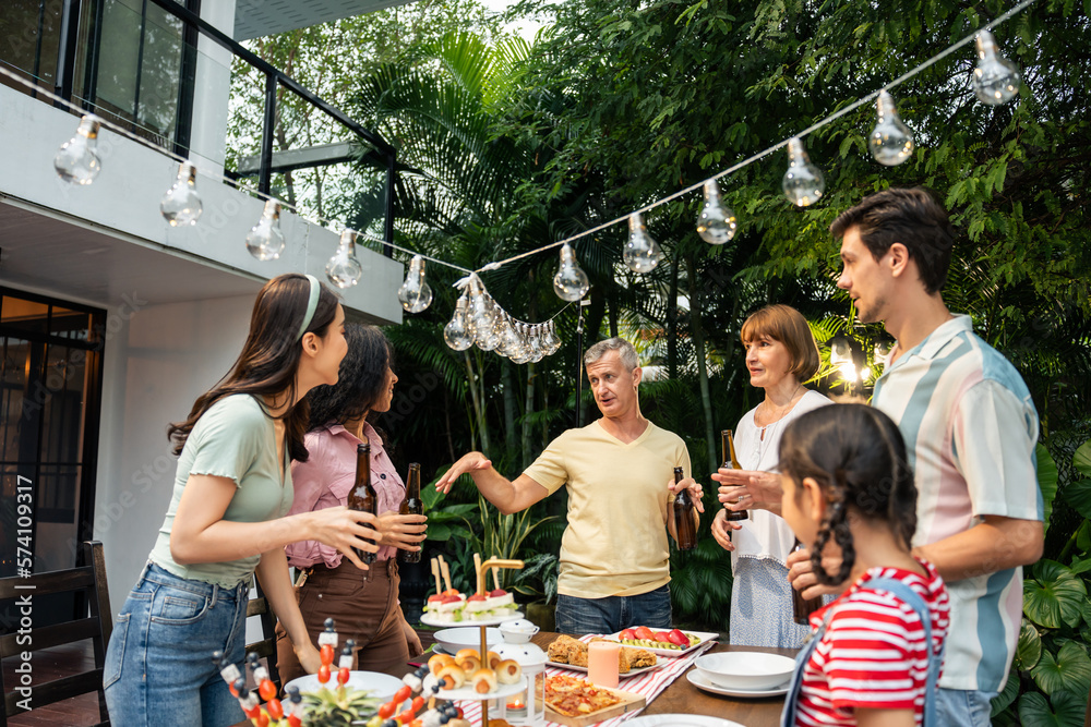 Multi-ethnic big family having fun, enjoy party outdoors in the garden. 