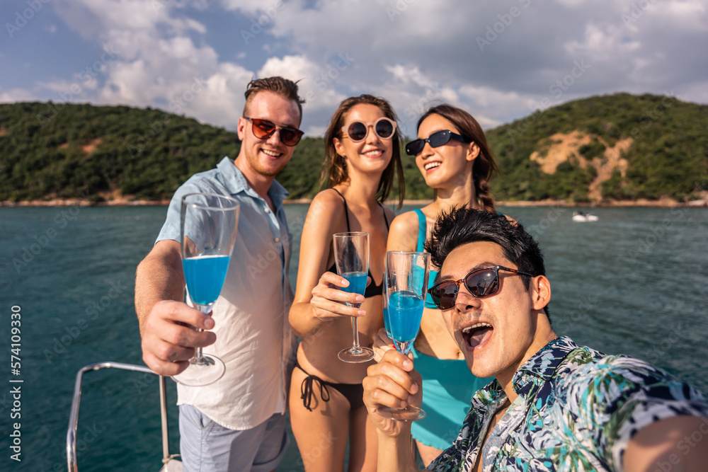 Group of diverse friends drink champagne while having a party in yacht. 