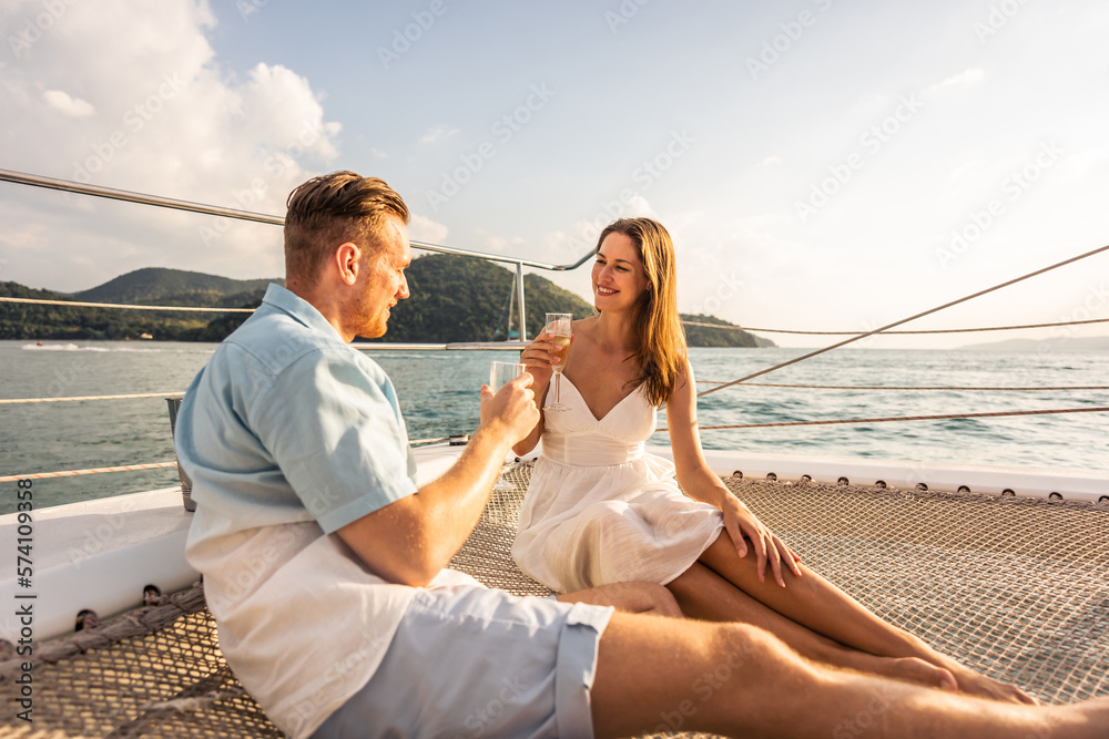 Caucasian young couple drinking champagne while having party in yacht. 