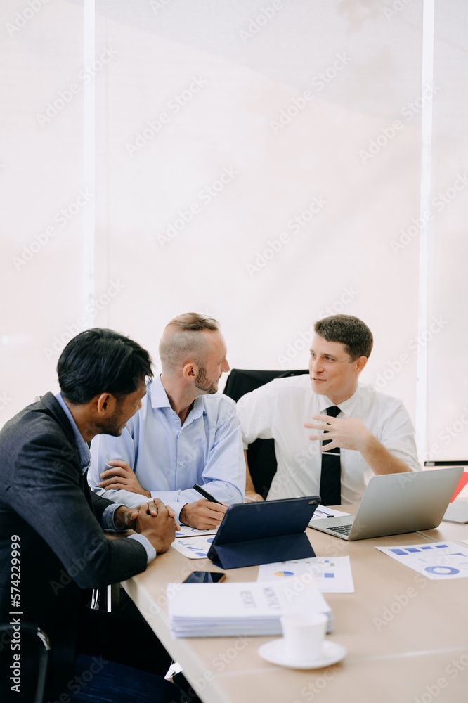 Office colleagues have a casual discussion. During a meeting in conference room, a group of business