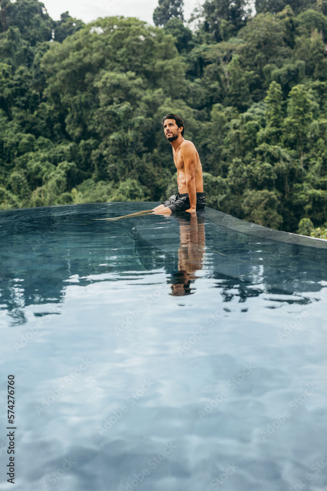 Man sitting on the edge of swimming pool