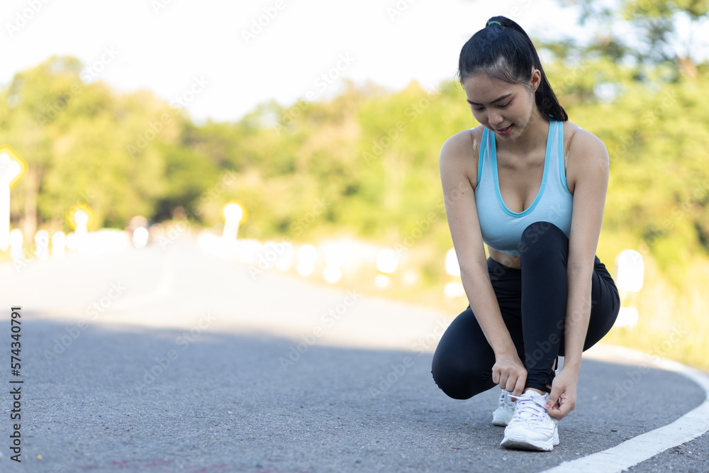 Woman running athlete tying shoelaces. Get ready to start exercising or running. Healthy lifestyle c