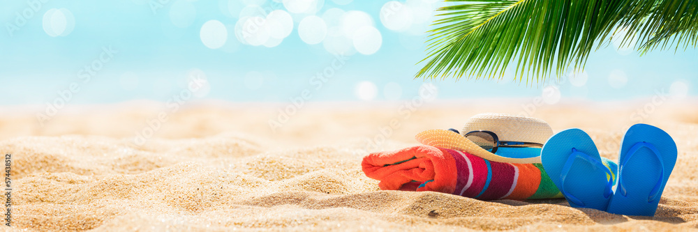 Summer holiday background with flip flops and palm tree on sandy beach