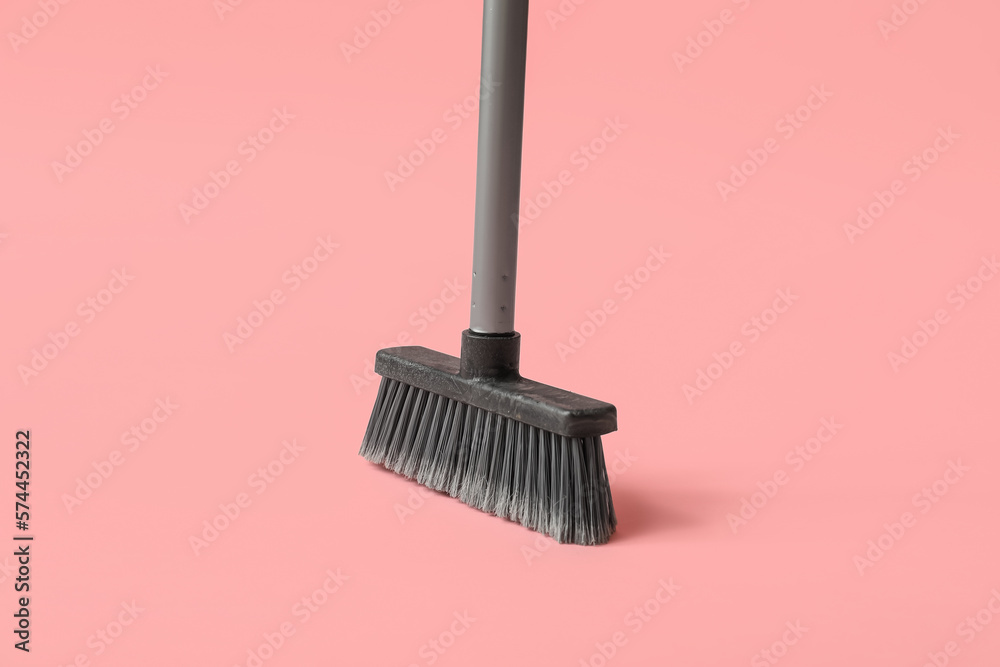 Plastic cleaning broom on pink background