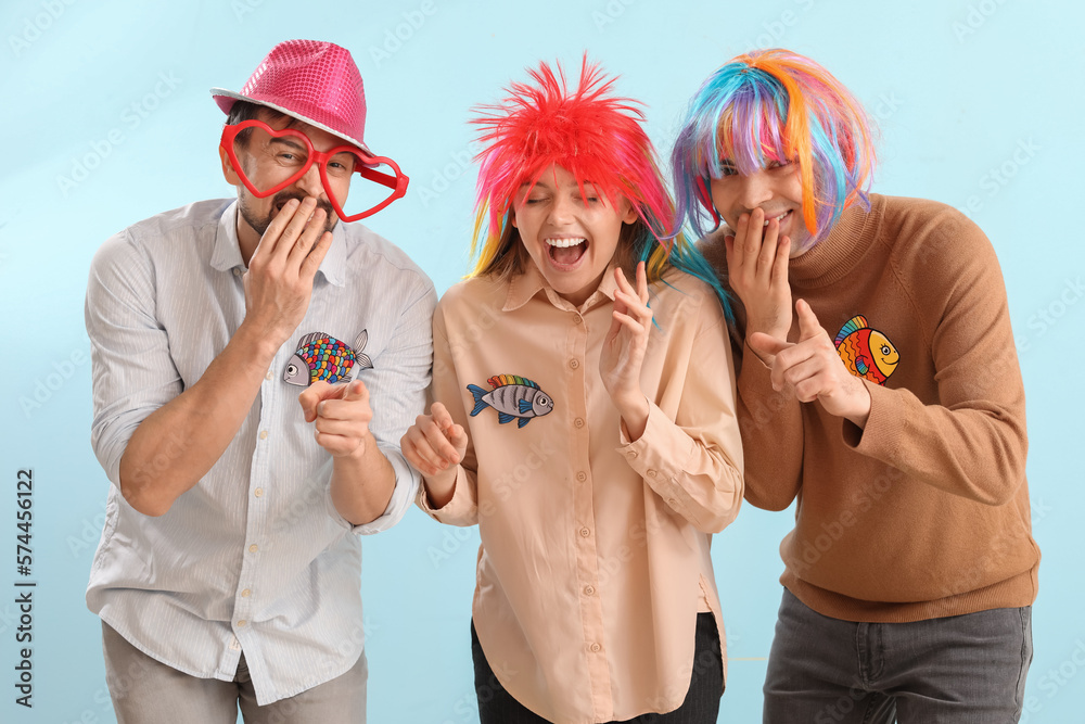 Business colleagues in funny disguise laughing on blue background. April Fools Day celebration