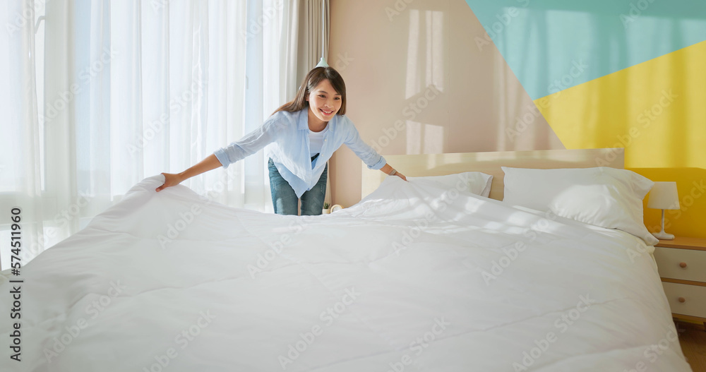 woman changes bed quilt